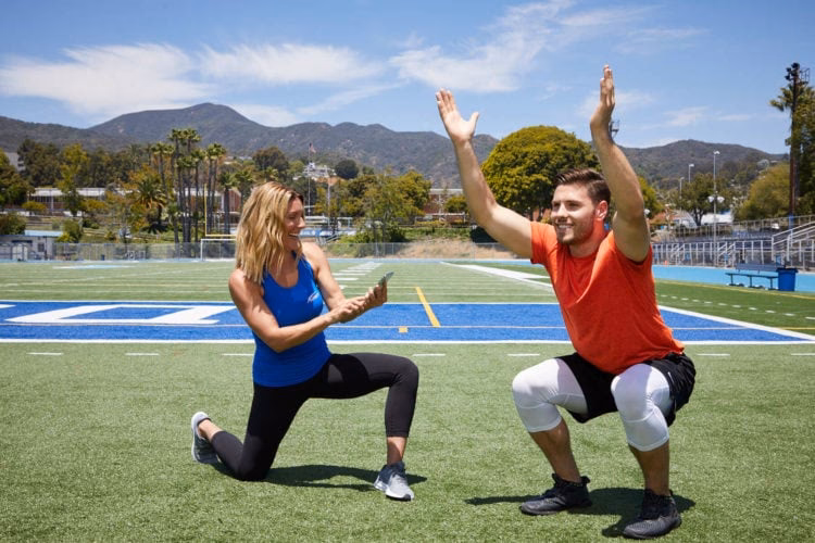How does a client perform an overhead squat?